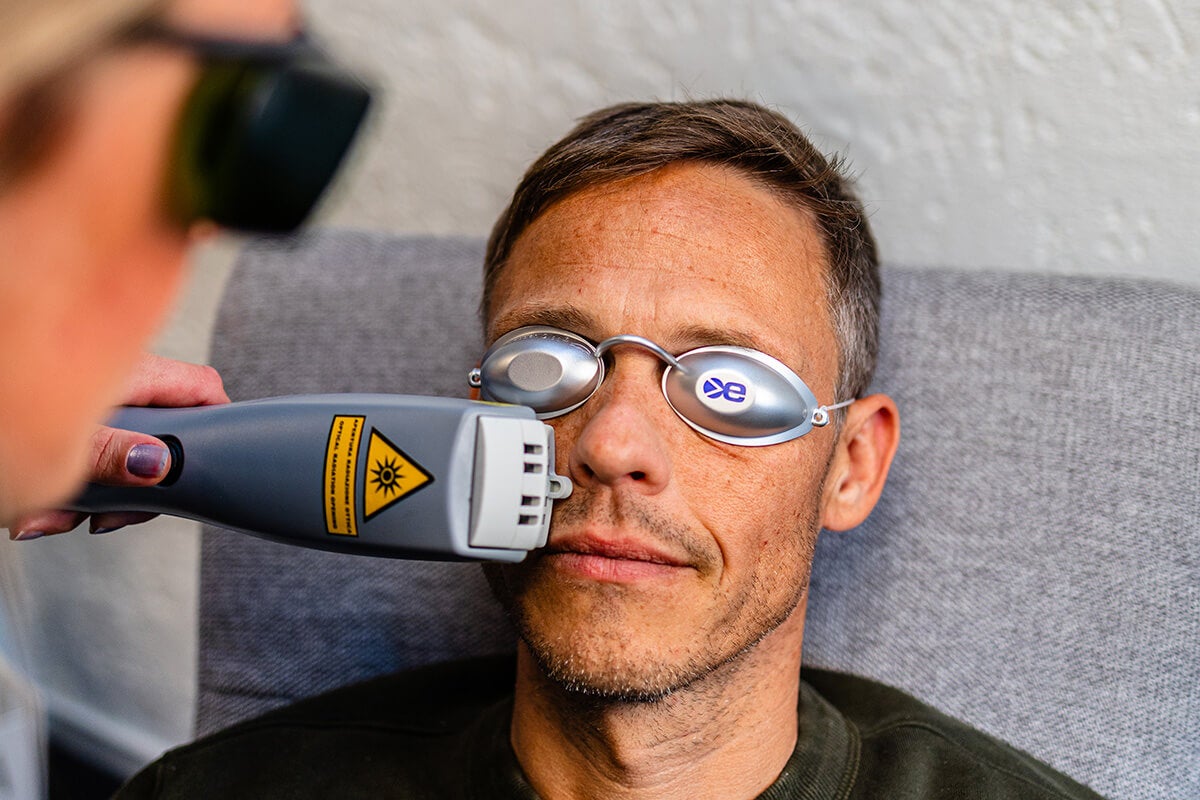 Mann som sitter i stol og får IPL-behandling